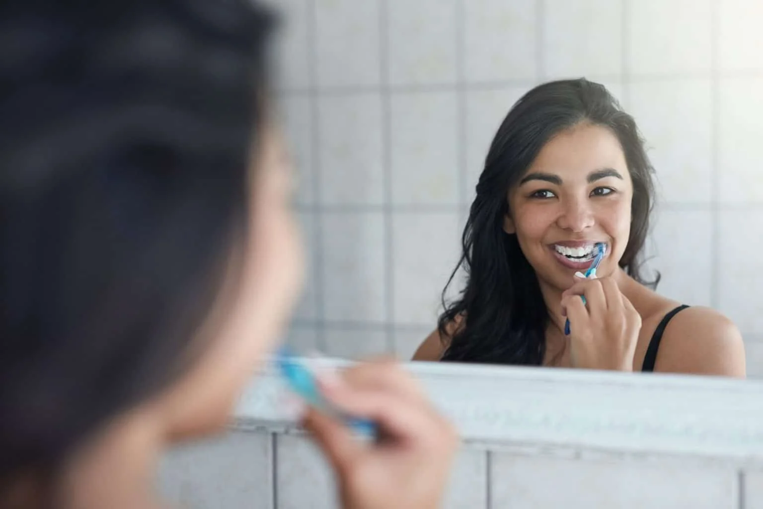 taking care her pearly whites shot attractive young woman brushing her teeth bathroom